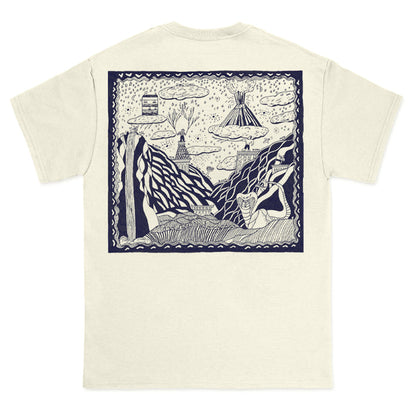 Cream-colored Comfort Colors t-shirt by The Story So Far, featuring a large navy-outlined graphic on the back with a whimsical, hand-drawn scene of mountains, clouds, trees, and a tent among abstract nature elements.