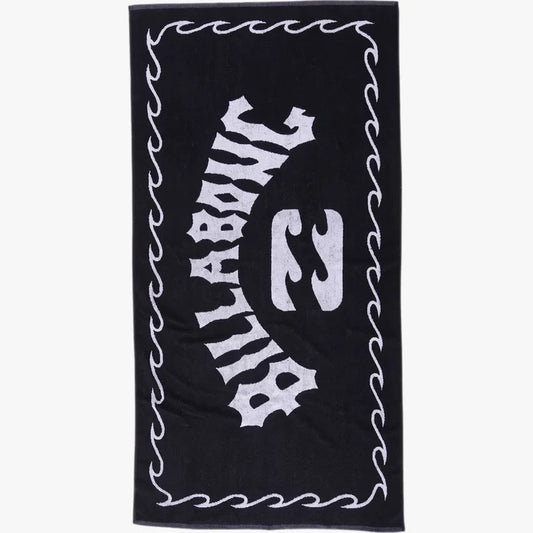 Black Billabong Arch Beach Towel with a white logo and wavy border, made from soft terry cloth, in a flat-lay view.