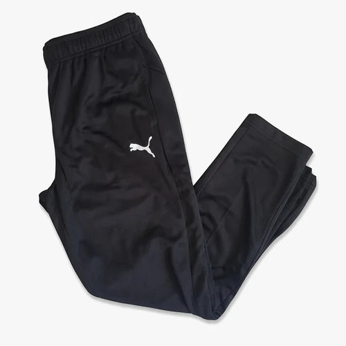 Black Puma Boys Za track pants, folded and displaying the white Puma logo, suitable for athletic wear or casual comfort.